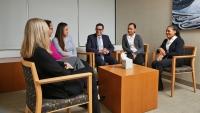 A group of people sitting in an office space having a discussion